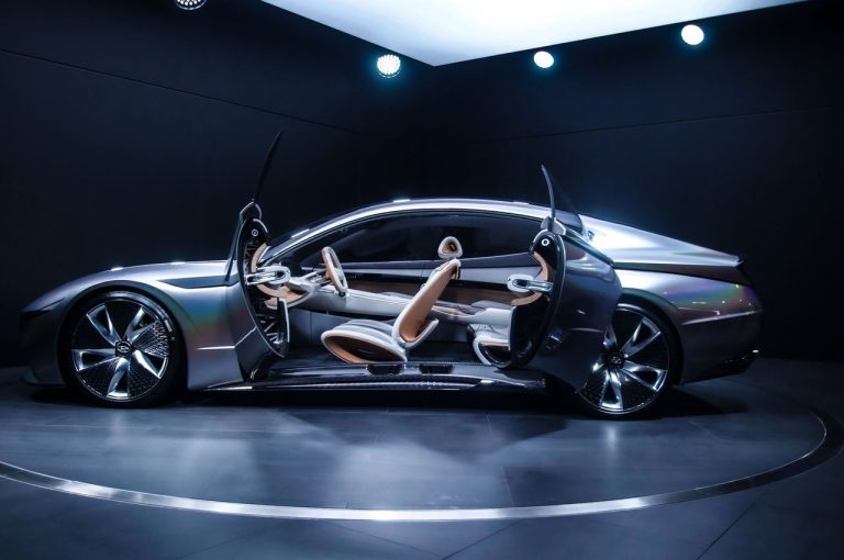 O que o conceito Multiplay revela sobre o futuro dos carros versáteis Carro-conceito futurista exposto em ambiente interno, com portas do tipo tesoura abertas.