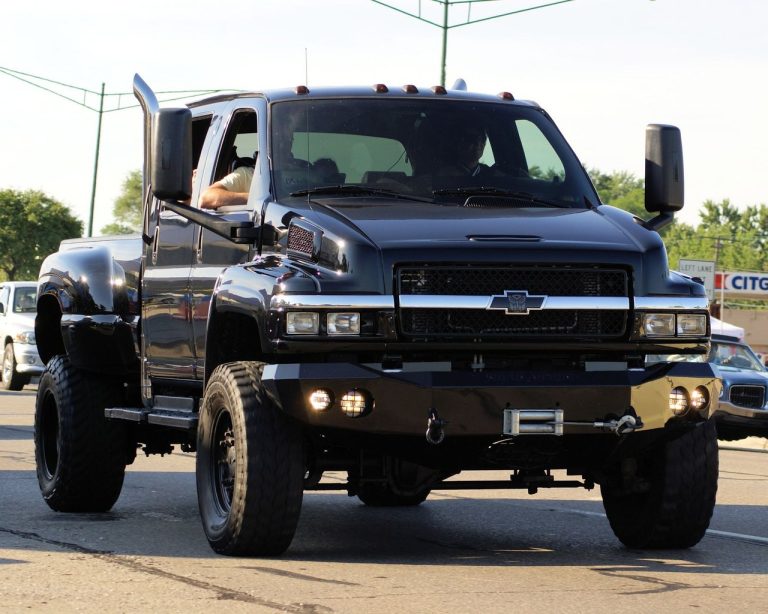 GM Defense transforma Chevrolet Silverado em plataforma não tripulada para missões especiais Picape Chevrolet preta circula por uma rua urbana durante o dia.